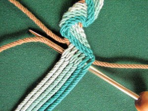 A gripfid pulling a cord through a braid for a necklace